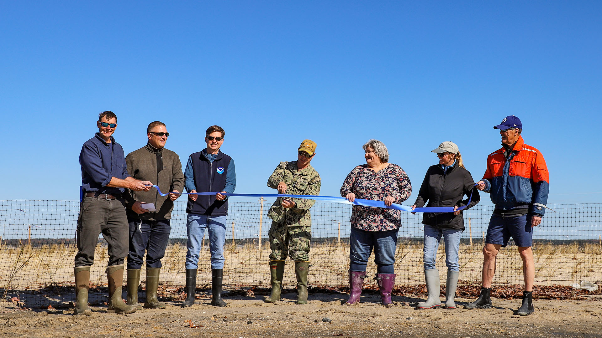 Flanked by project stakeholders, Captain Dan Patrick, NWSY commanding officer, cuts a celebratory ribbon signaling an end to the nearly five-year project to stabilize, protect and restore Penniman Spit. U.S. Navy photo by Max Lonzanida.